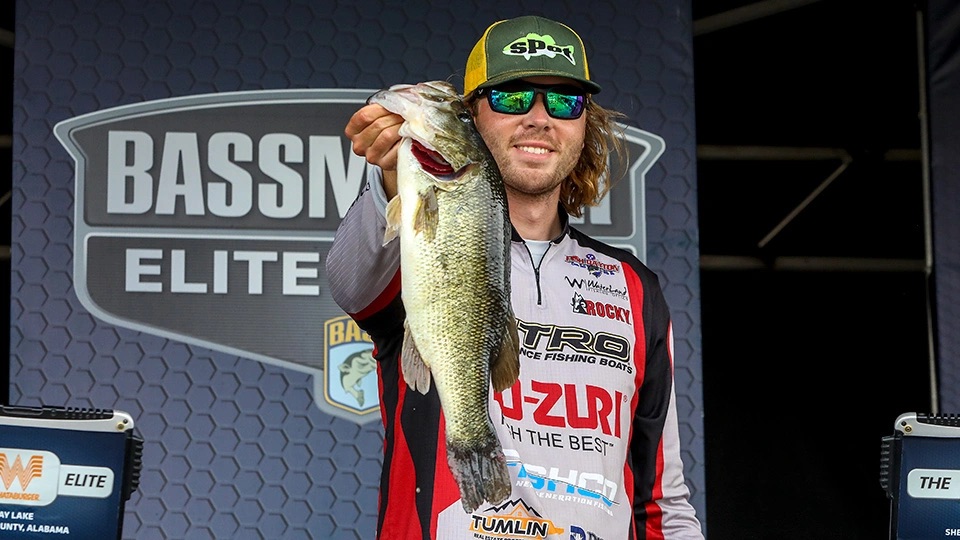 Cole Sands holding a bass on Bassmaster Elite Series stage
