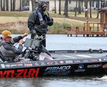 Cole Sands landing a bass during a Elite Series event with a Witch Doctor Tackle rod.