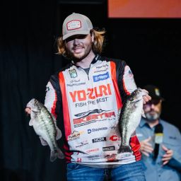 Cole Sands on stage with two bass at the 2024 Bassmaster Classic.